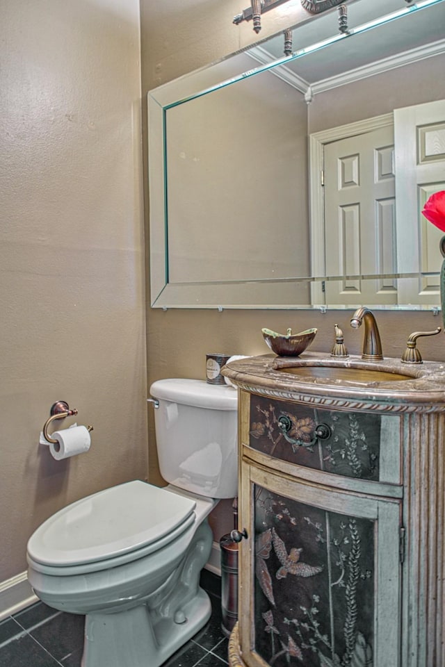 bathroom with tile patterned flooring, toilet, vanity, and baseboards