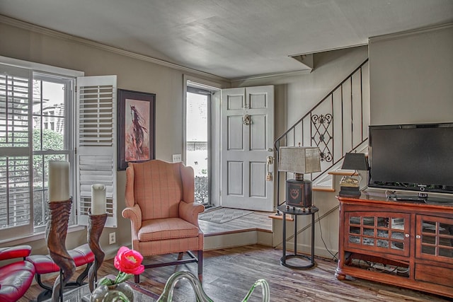 entrance foyer featuring wood finished floors, ornamental molding, and stairs