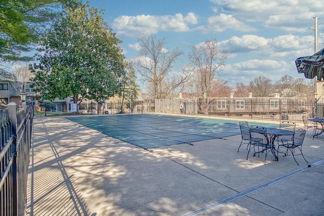 pool with a patio area and fence