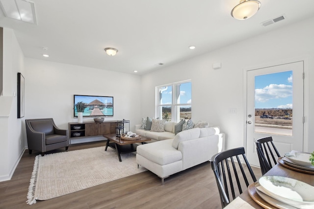 living room with recessed lighting, wood finished floors, and visible vents
