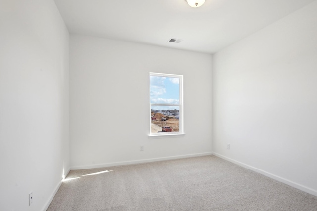 empty room featuring visible vents, baseboards, and carpet flooring