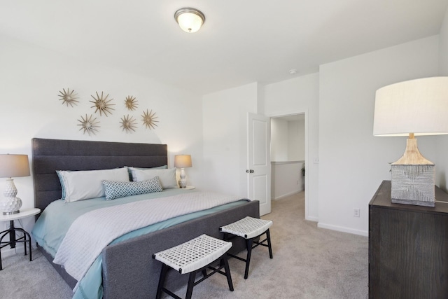 bedroom with baseboards and light colored carpet