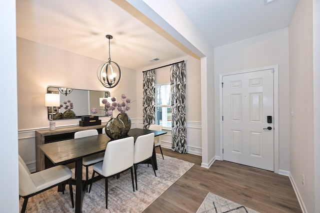 dining room with an inviting chandelier, wainscoting, visible vents, and dark wood-type flooring