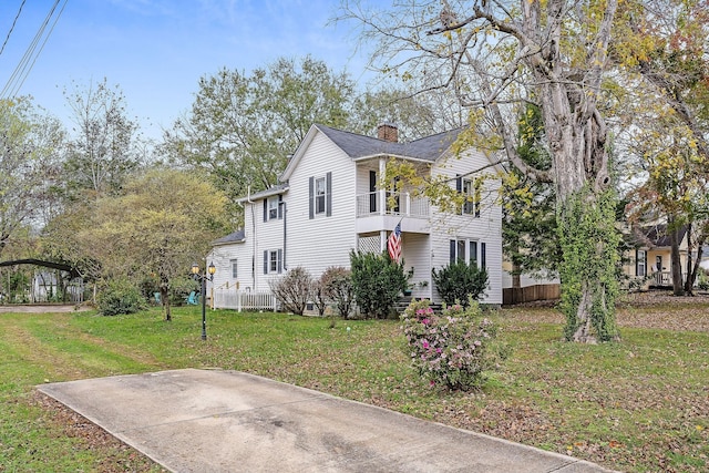 view of home's exterior featuring a lawn, a chimney, and a balcony