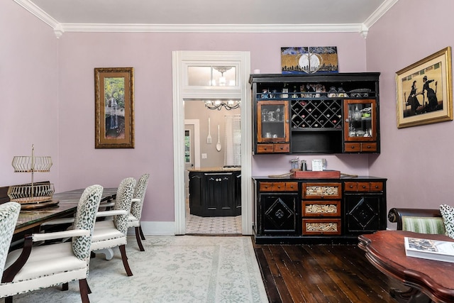 bar with dark wood-type flooring, baseboards, and ornamental molding