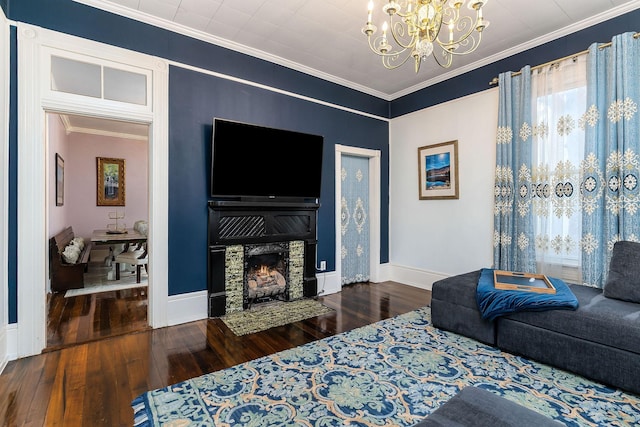 living area with a notable chandelier, ornamental molding, baseboards, and hardwood / wood-style flooring