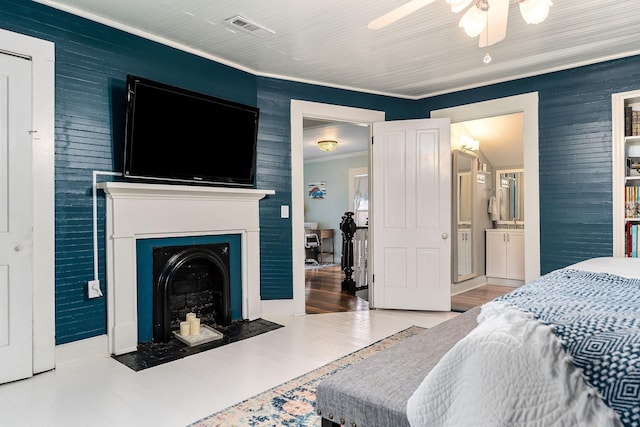 bedroom with visible vents, a fireplace with flush hearth, ceiling fan, and ornamental molding