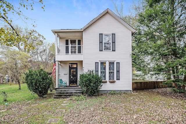 view of front of property with a balcony and fence