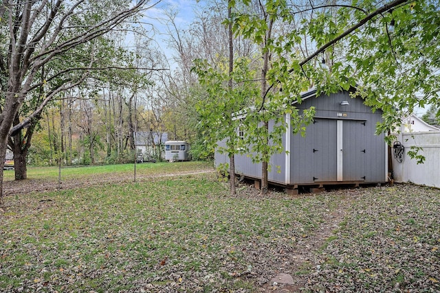 view of yard featuring a storage unit and an outbuilding