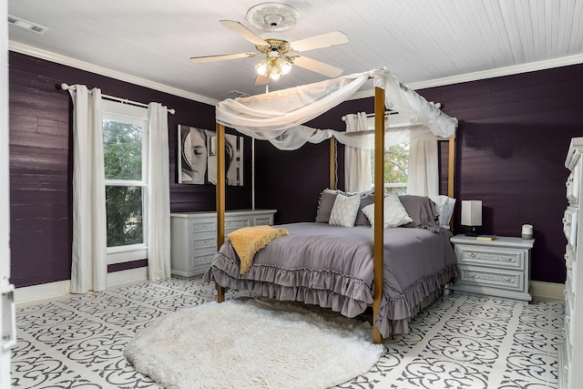 bedroom with a ceiling fan, visible vents, wood walls, and baseboards