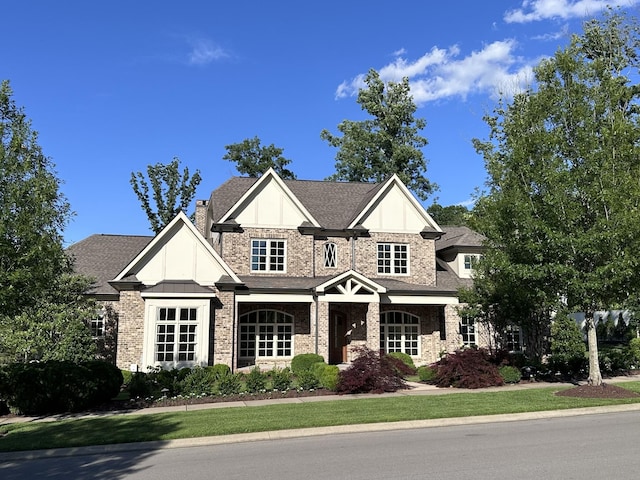 craftsman house featuring brick siding and a shingled roof