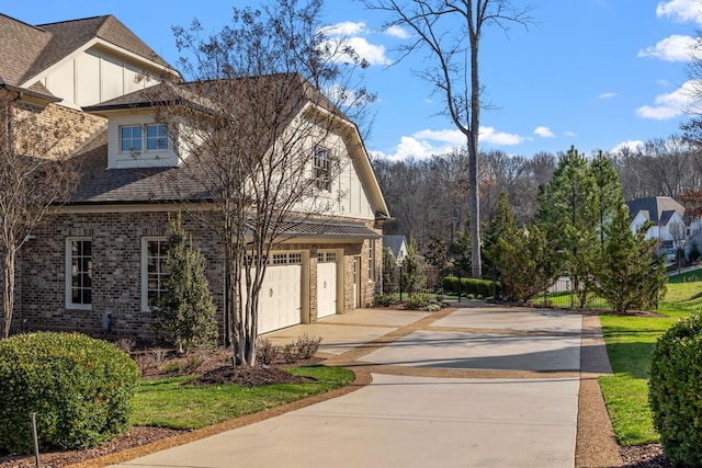 view of side of property featuring board and batten siding, concrete driveway, an attached garage, and fence