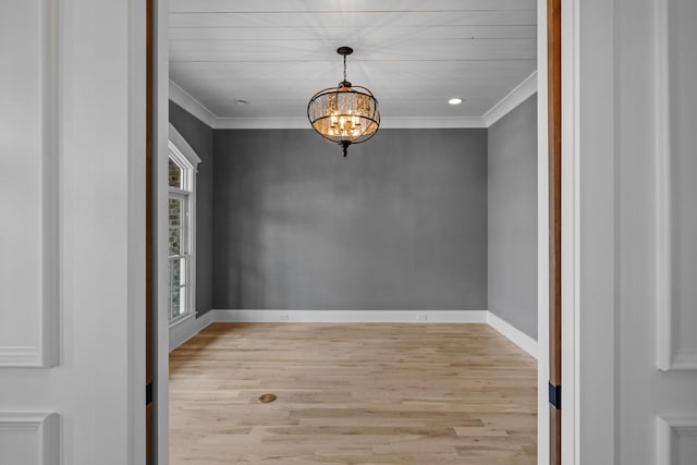 interior space with a notable chandelier, wood finished floors, and ornamental molding