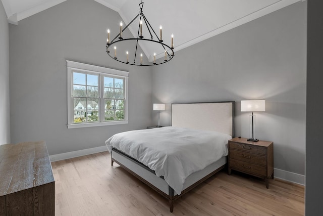 bedroom with baseboards, a notable chandelier, crown molding, and light wood finished floors