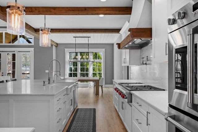 kitchen with tasteful backsplash, beam ceiling, appliances with stainless steel finishes, and custom range hood