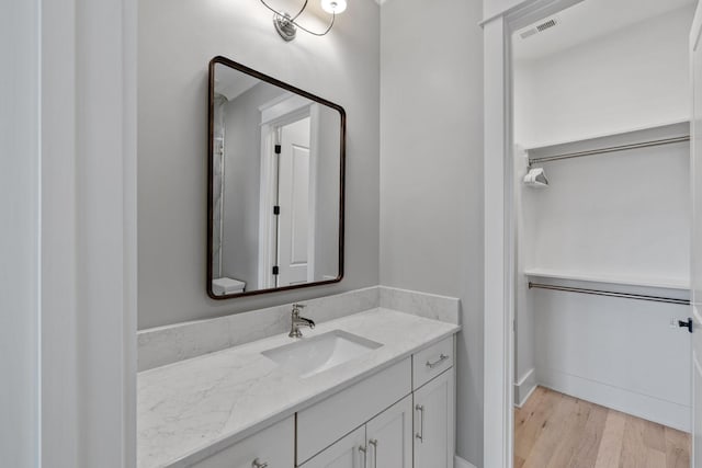 bathroom featuring visible vents, wood finished floors, and vanity