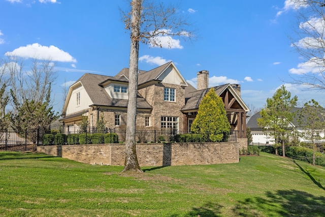 rear view of house with a yard and fence