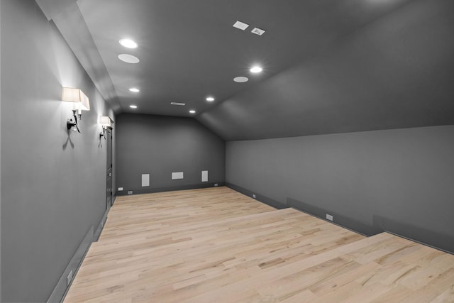 additional living space with lofted ceiling, recessed lighting, baseboards, and light wood finished floors