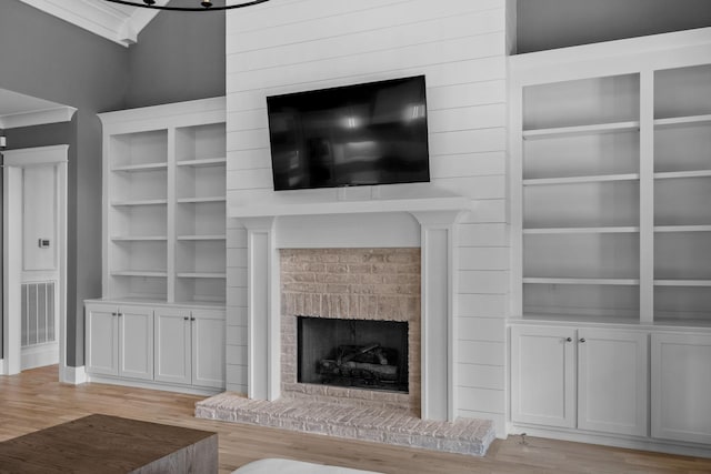 unfurnished living room featuring visible vents, a brick fireplace, and wood finished floors