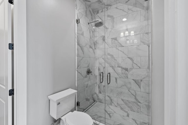 bathroom with a shower stall and toilet