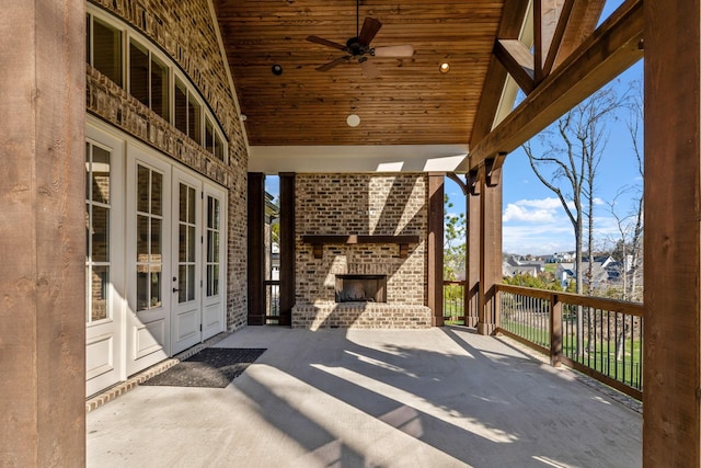 view of patio with french doors and an outdoor brick fireplace