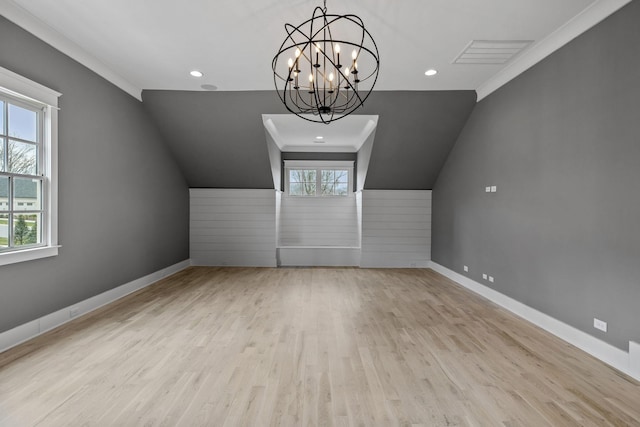 additional living space with visible vents, lofted ceiling, wood finished floors, an inviting chandelier, and baseboards