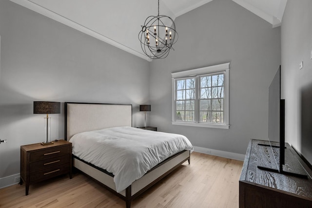 bedroom with a notable chandelier, crown molding, baseboards, and wood finished floors