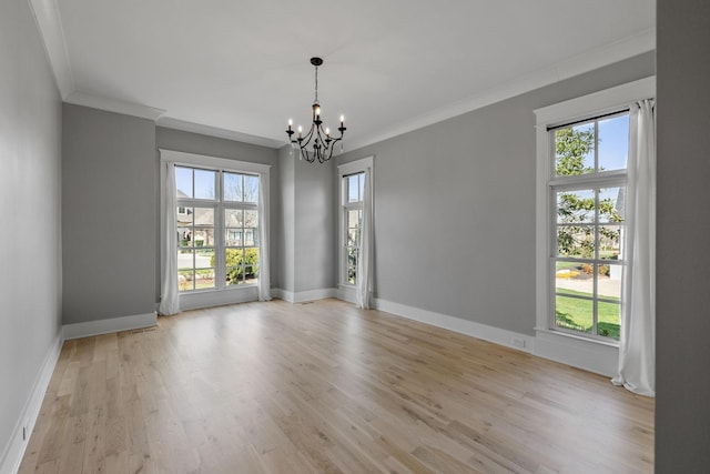 unfurnished room featuring baseboards, wood finished floors, a chandelier, and crown molding