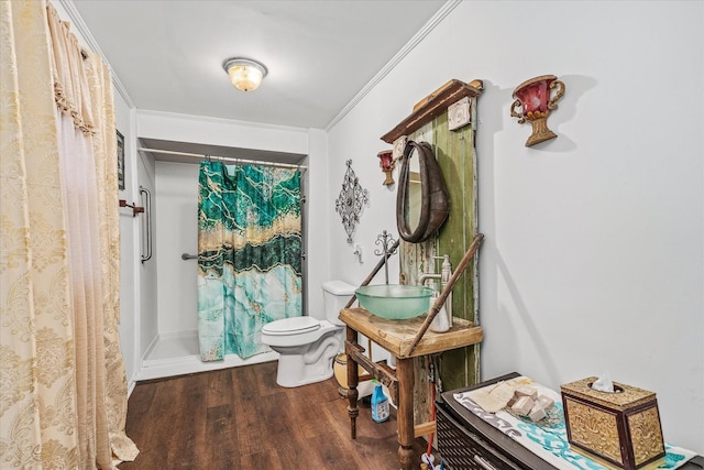 full bath featuring toilet, a sink, curtained shower, wood finished floors, and crown molding