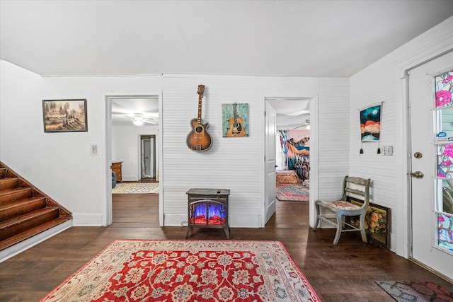 interior space with ceiling fan, baseboards, wood finished floors, and stairs