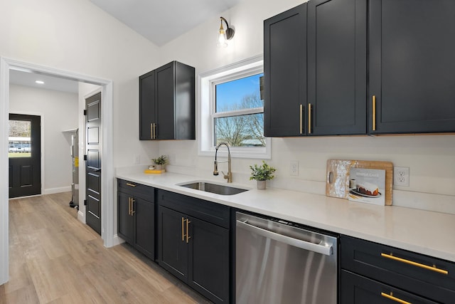 kitchen with a sink, light wood finished floors, dishwasher, and light countertops