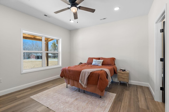 bedroom featuring visible vents, baseboards, and wood finished floors