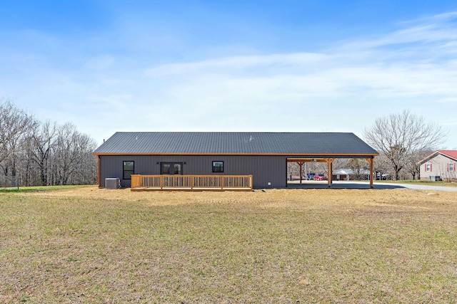 view of front of house with a front yard, central AC unit, a pole building, a carport, and metal roof