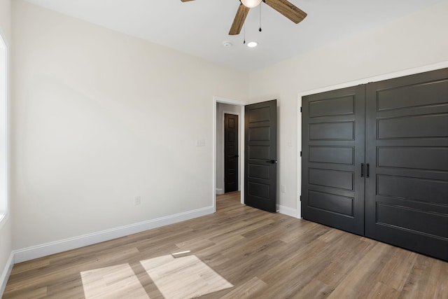 unfurnished bedroom featuring a closet, a ceiling fan, baseboards, and light wood finished floors