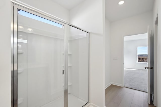 full bathroom featuring baseboards, wood finished floors, recessed lighting, and a shower stall