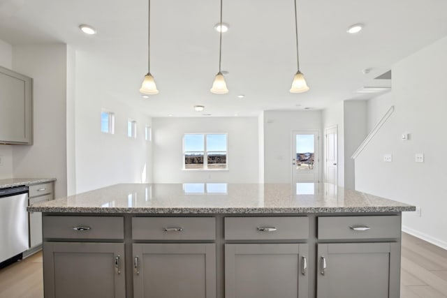 kitchen with gray cabinets, decorative light fixtures, dishwasher, and light stone countertops