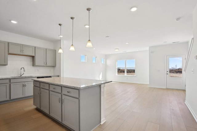 kitchen featuring tasteful backsplash, a sink, and gray cabinetry