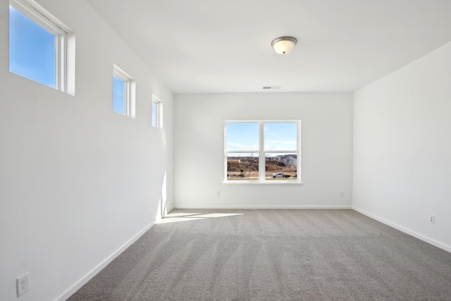 carpeted empty room with baseboards and visible vents