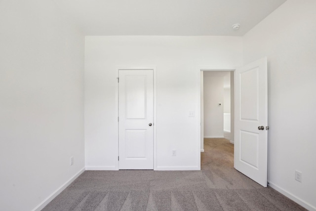 unfurnished bedroom with carpet floors and baseboards