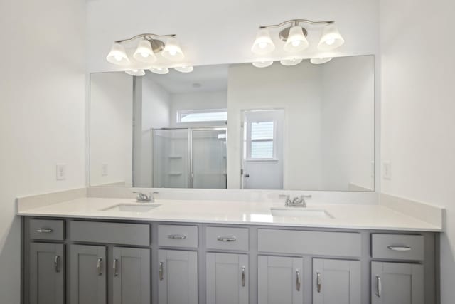 full bathroom featuring a sink, double vanity, and a stall shower