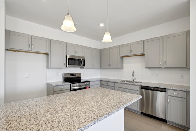 kitchen with gray cabinets, pendant lighting, appliances with stainless steel finishes, and a sink