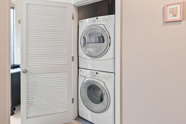 washroom with stacked washer and dryer and laundry area