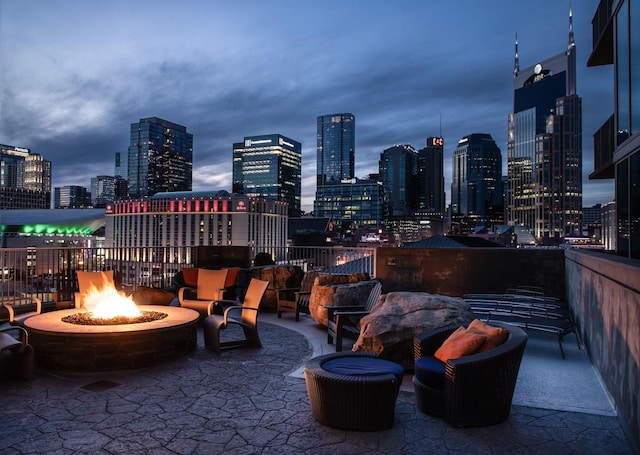 view of patio / terrace with an outdoor fire pit and a view of city