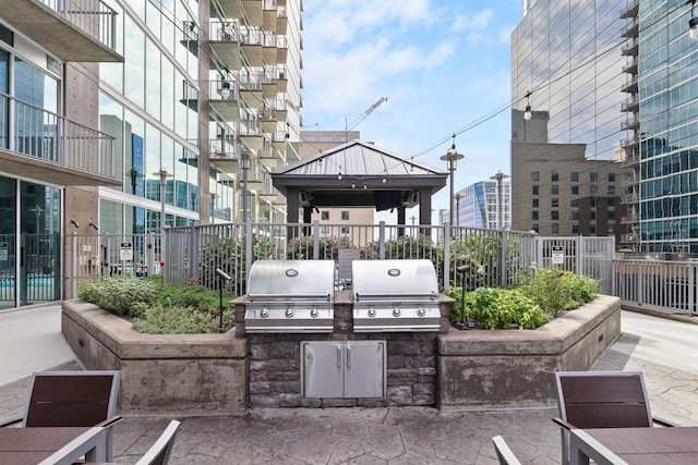 view of patio / terrace featuring exterior kitchen, area for grilling, and fence