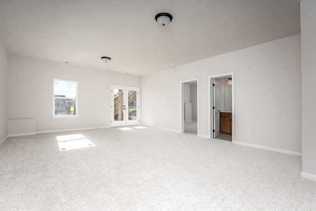 spare room featuring french doors, baseboards, and carpet floors