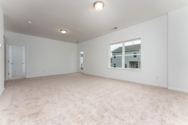 carpeted empty room featuring visible vents and baseboards