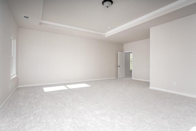 spare room featuring baseboards, carpet floors, a raised ceiling, and visible vents
