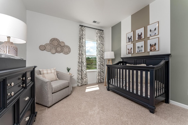 bedroom with visible vents, light colored carpet, baseboards, and a nursery area