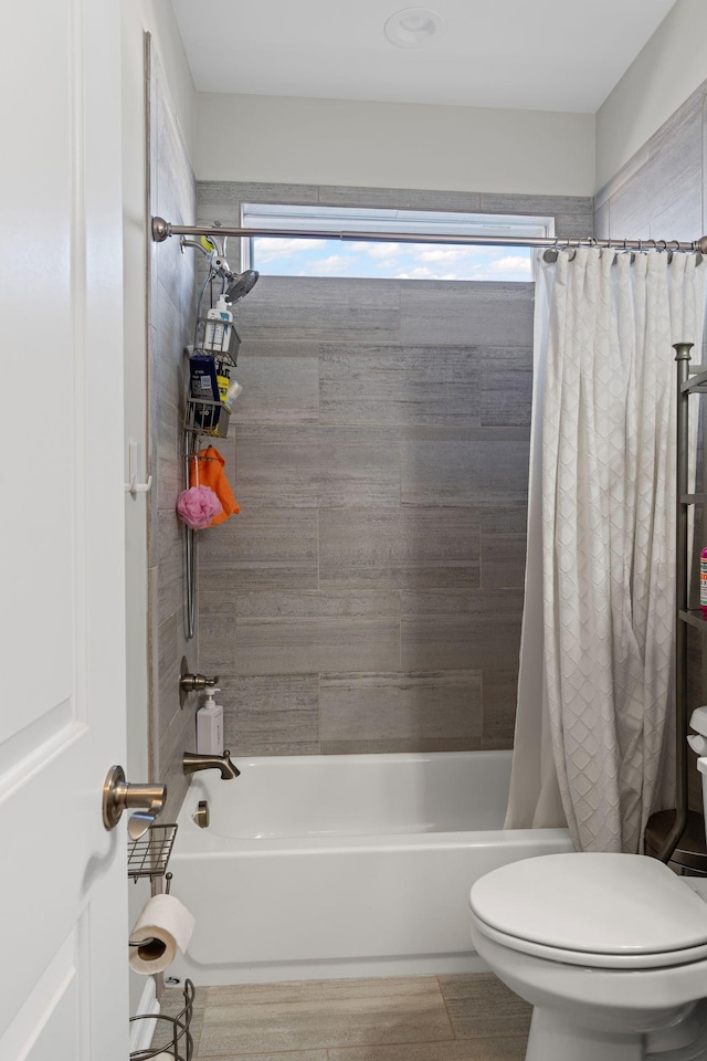 bathroom featuring a wealth of natural light, shower / bath combo with shower curtain, and toilet