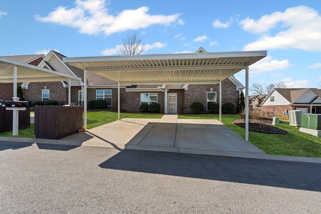 view of front of house featuring a carport, brick siding, and a front lawn